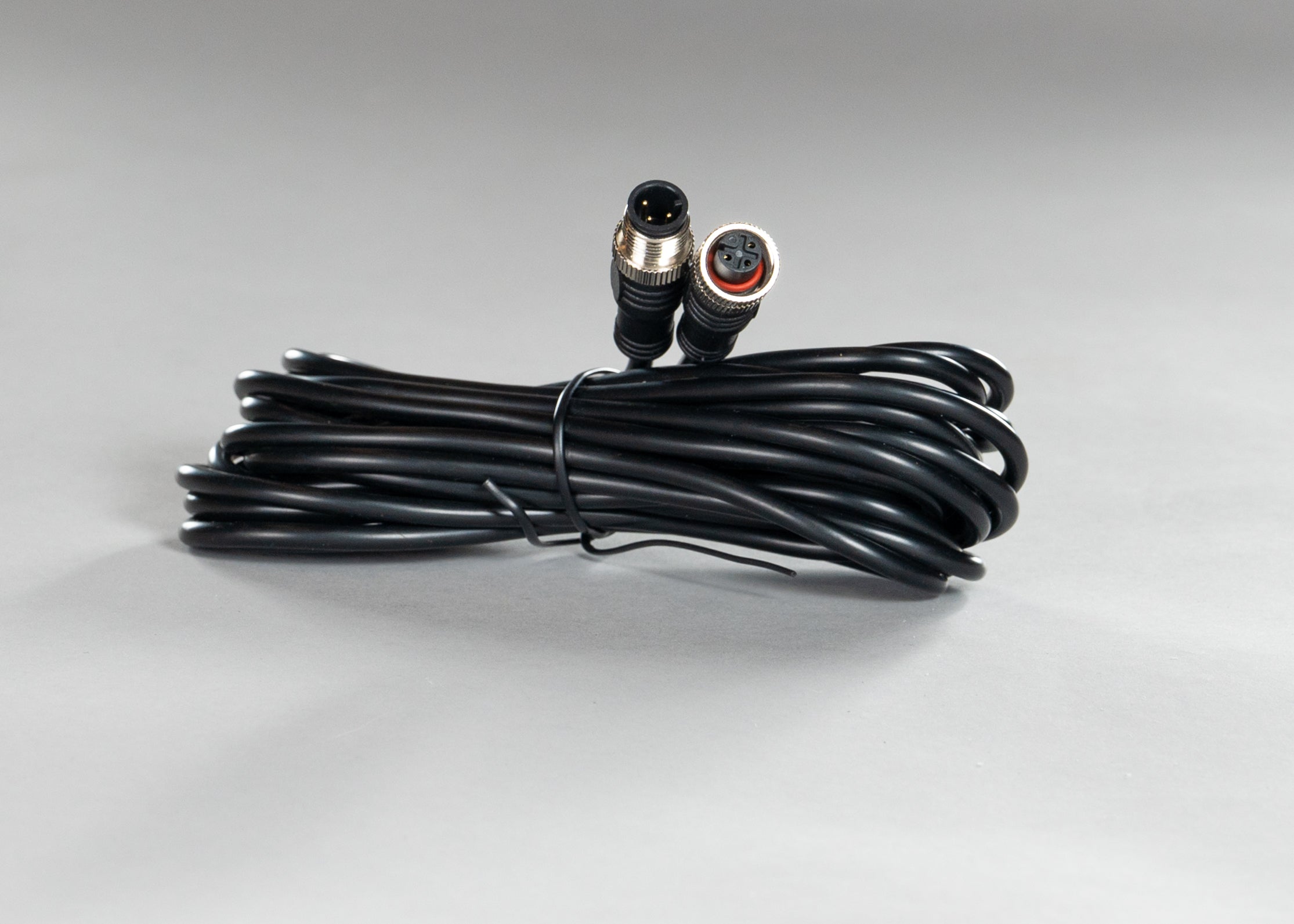Black power cable with three pin connectors coiled and fastened with twist tie.